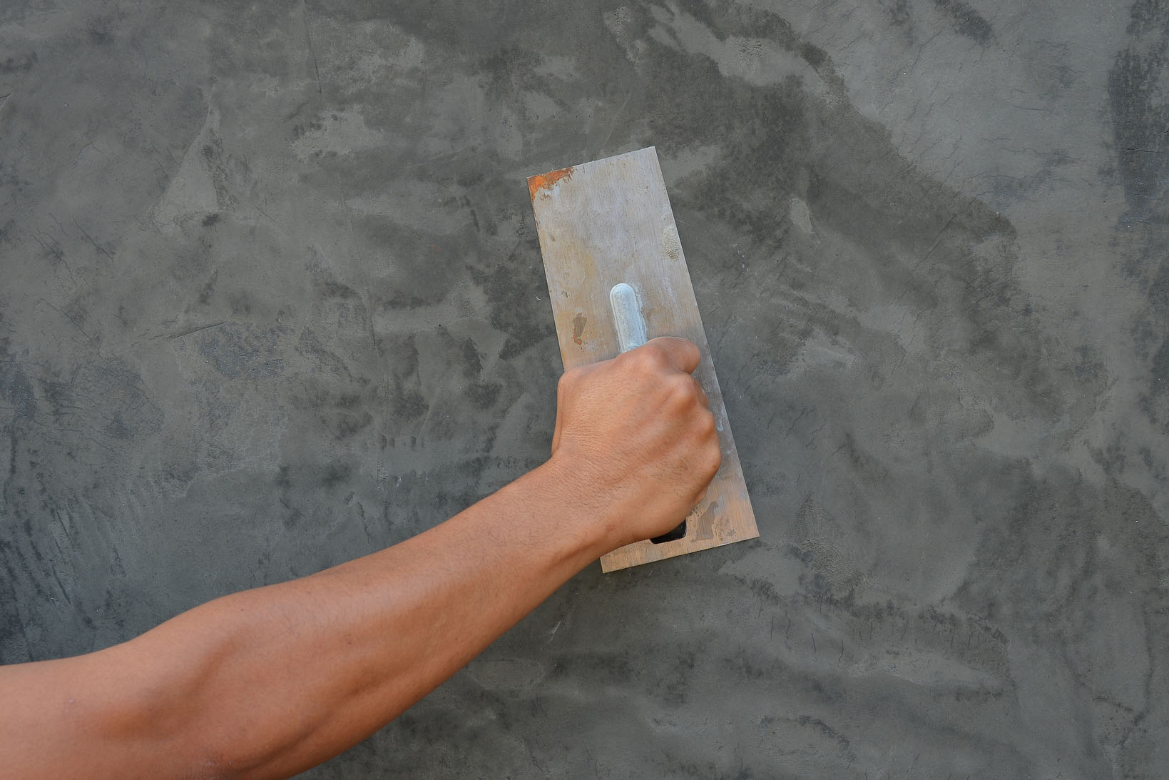 plasterer concrete worker at wall of house construction